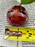 carnelian sphere with measuring tape showing approx 1.5"