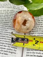 Carnelian sphere showing druzy and measuring tape to show the size - approx 1.5"