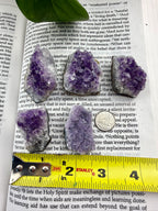 amethyst clusters with measuring tape showing them to be about 1 inch wide