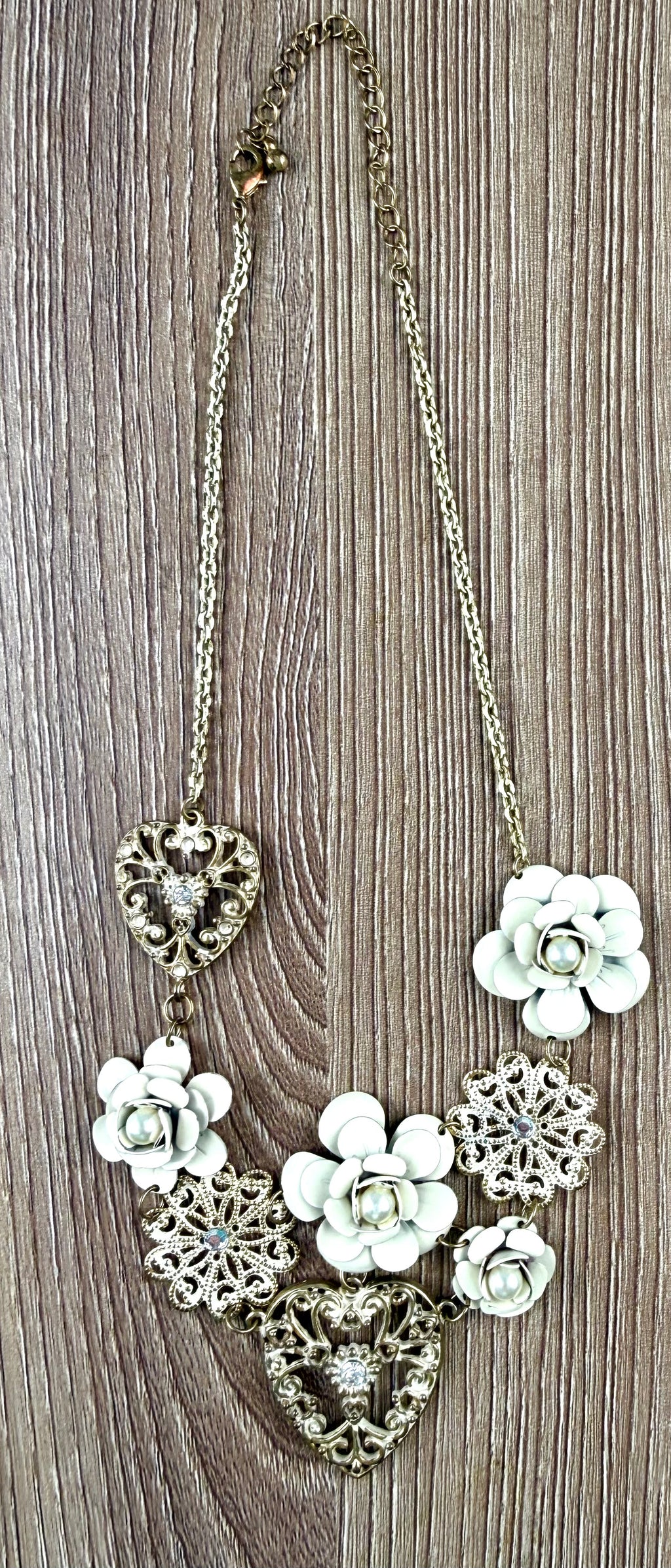 Antique gold-tone filigree heart and ivory enamel rose cluster statement necklace laid flat with measuring tape, full length view, rhinestone accents visible — Blue Sparrow pre-loved jewellery