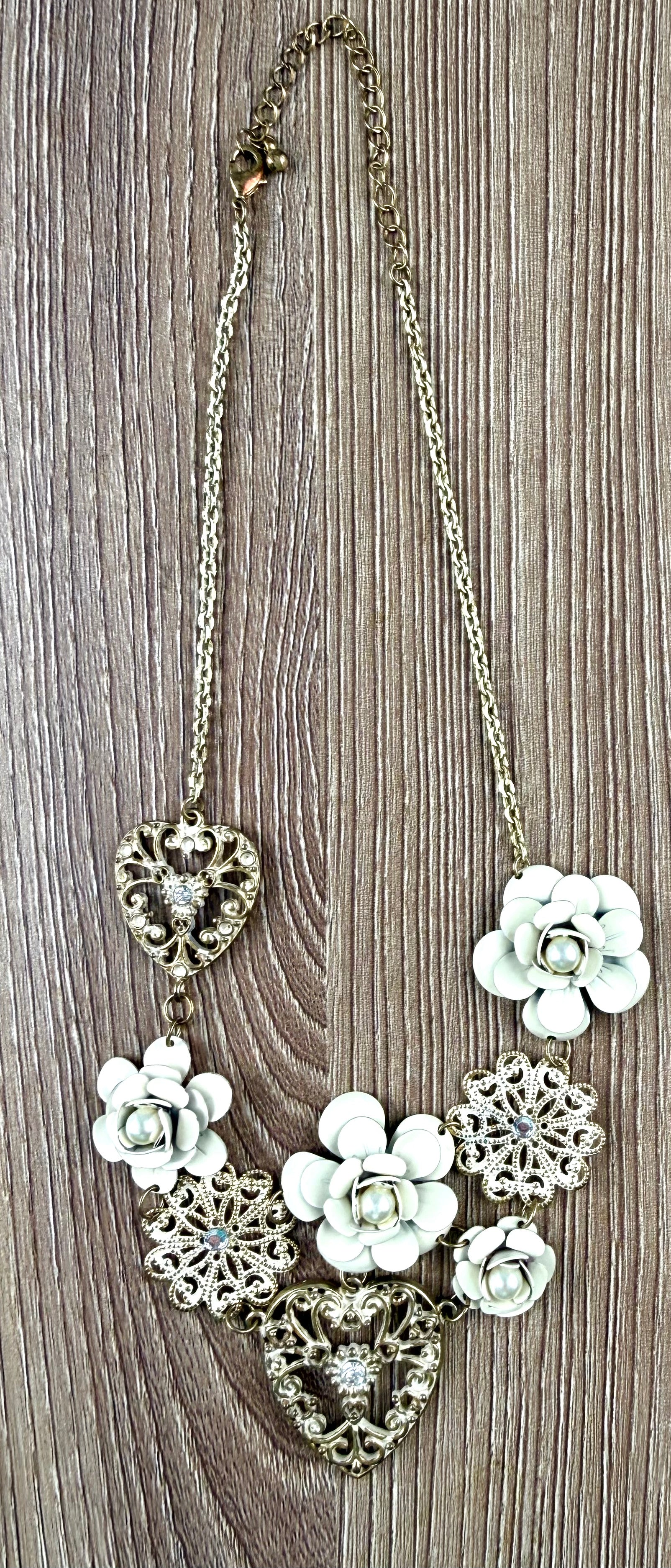 Antique gold-tone filigree heart and ivory enamel rose cluster statement necklace laid flat with measuring tape, full length view, rhinestone accents visible — Blue Sparrow pre-loved jewellery