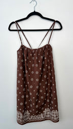 Aritzia brand brown floral dress on a hanger against a white background