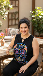 ¡Ay Güey! black sleeveless sugar skull embroidered tank top, Día de los Muertos multicolour embroidery at Blue Sparrow Shop  on woman sitting outside 