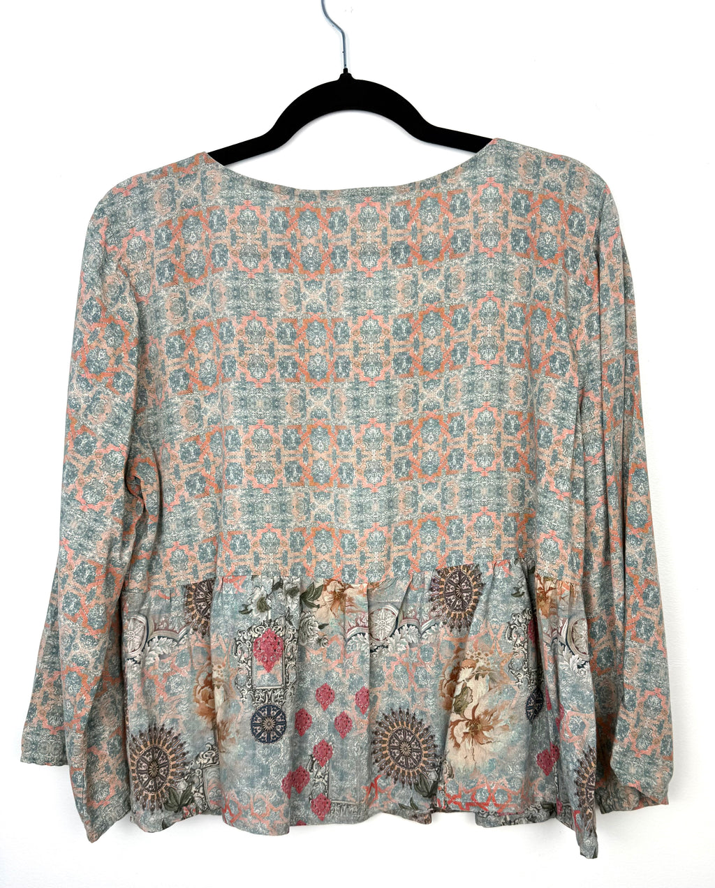 Back view of Mahla mixed print blouse in soft sage and coral geometric pattern with flowy peplum hem and relaxed silhouette in breathable modal fabric.