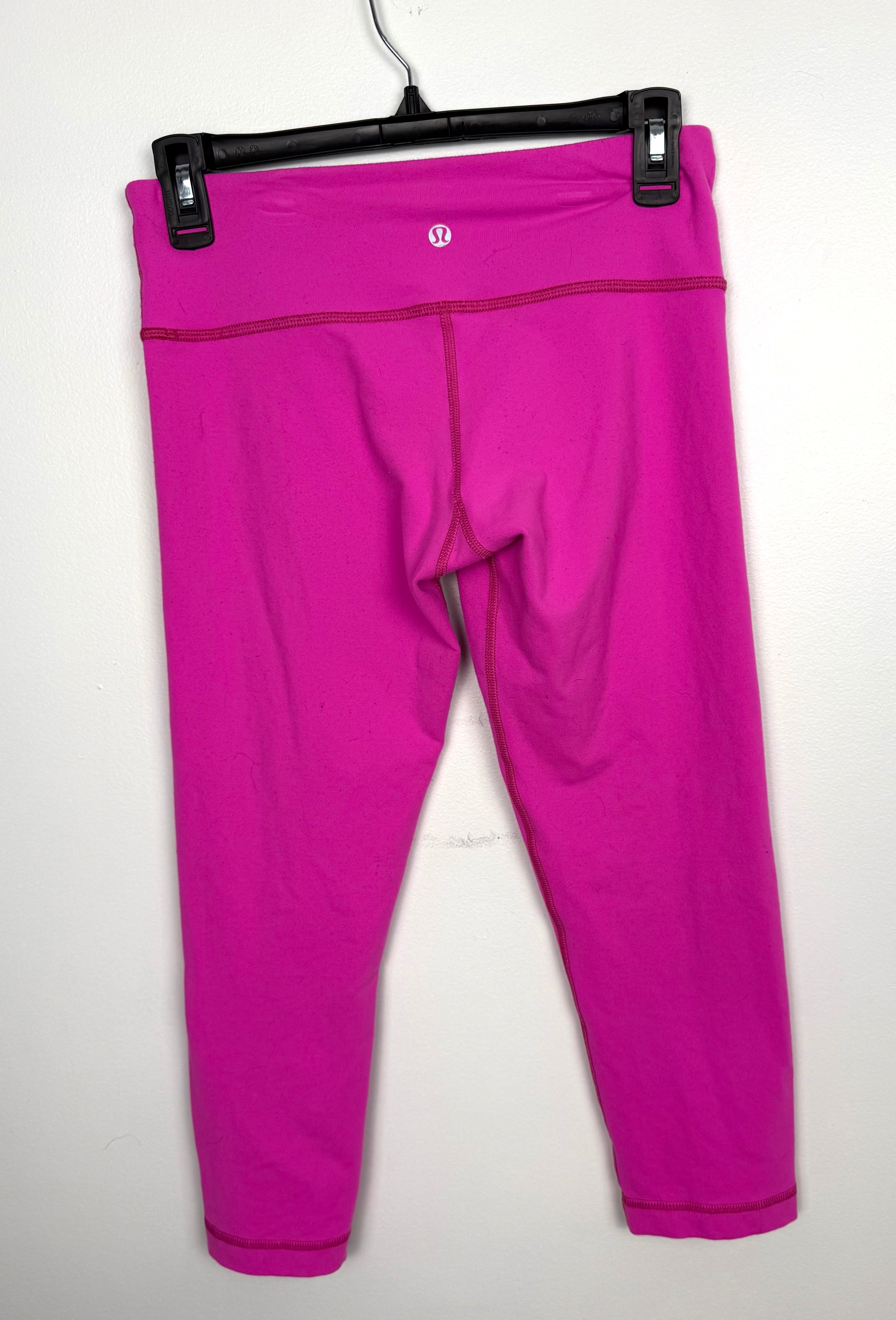 Back view of lululemon hot pink capris showing logo and waistband