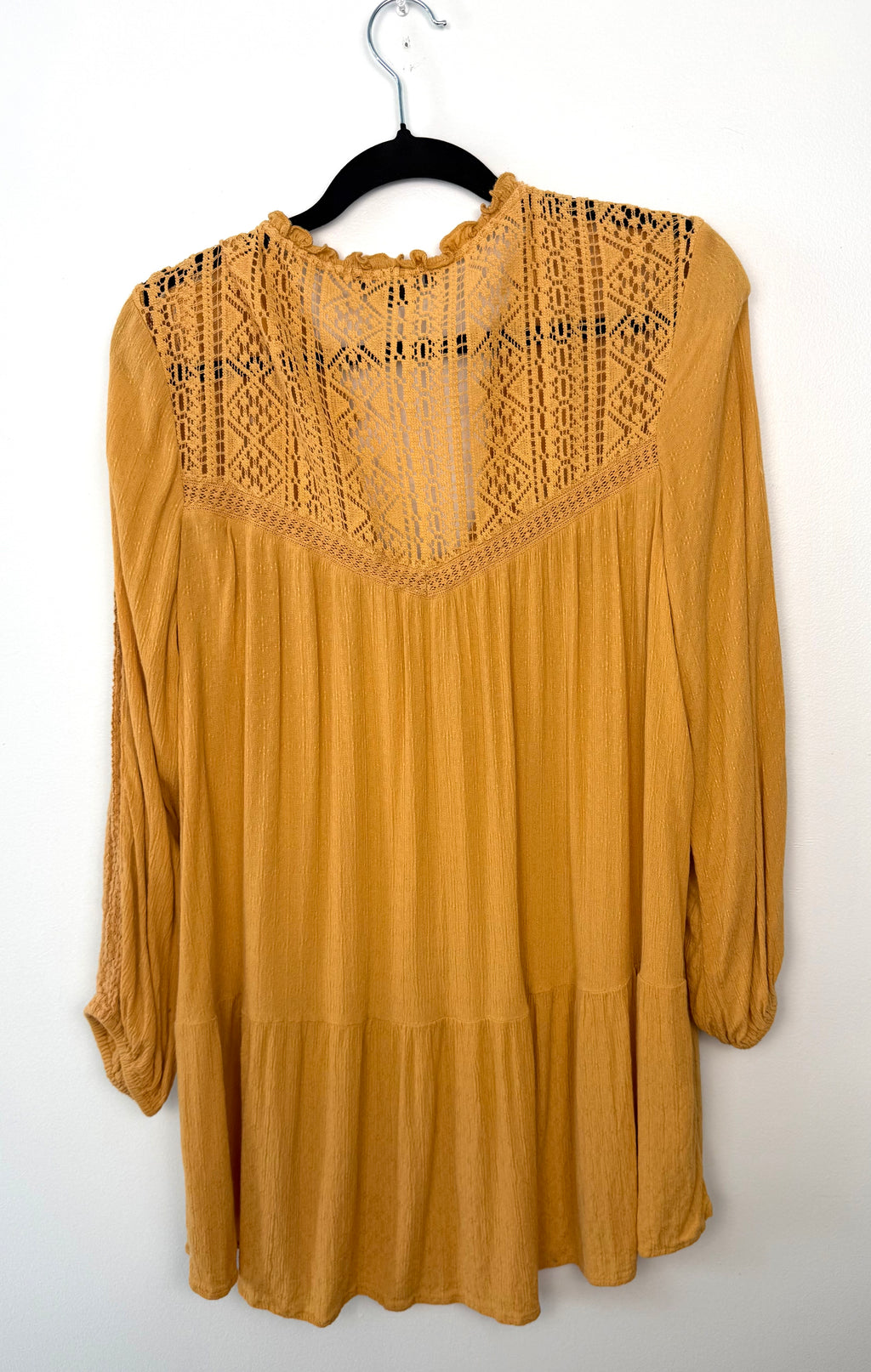 Back view of mustard American Eagle tunic featuring intricate lace panel across shoulders and relaxed flowy silhouette.