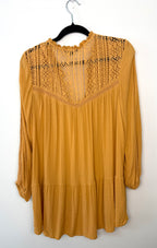 Back view of mustard American Eagle tunic featuring intricate lace panel across shoulders and relaxed flowy silhouette.
