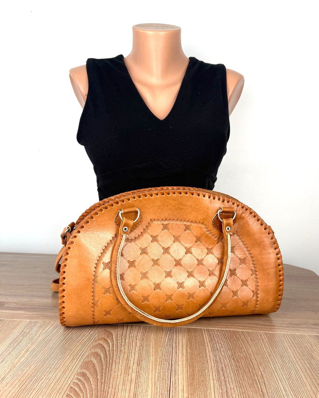 Back view of vintage tan leather handbag featuring geometric tooled leather design