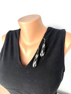 Black and white geometric drop earrings styled on black V-neck top for scale and styling reference.