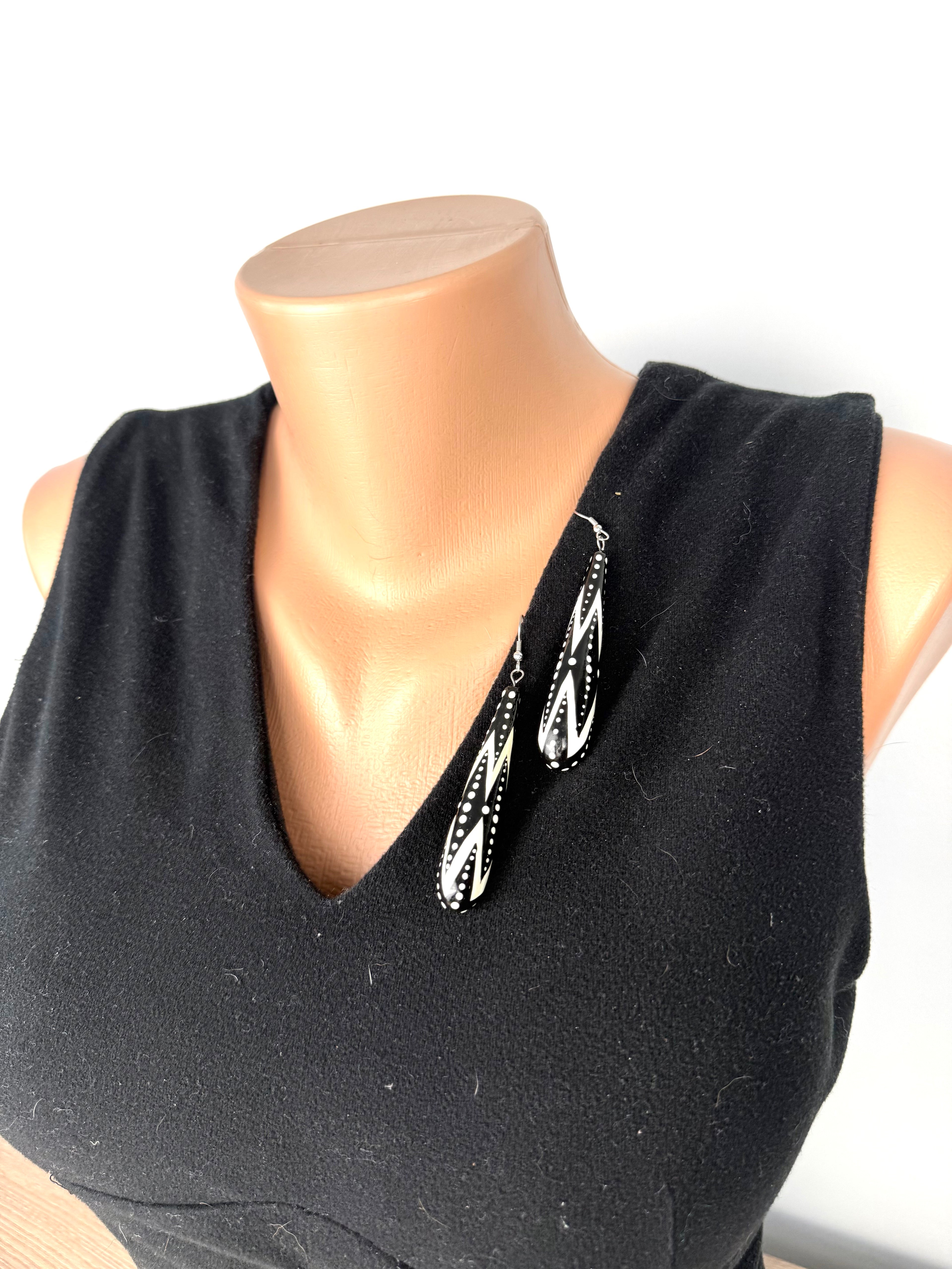 Black and white geometric drop earrings styled on black V-neck top for scale and styling reference.