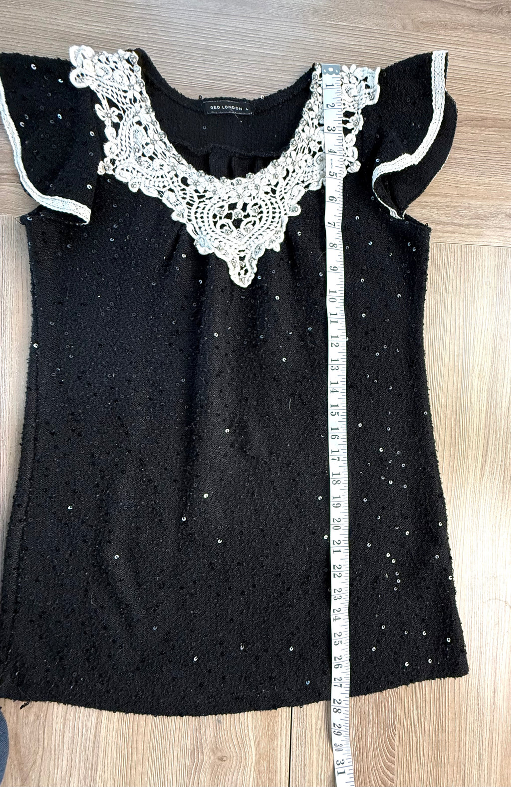 Black sequinned top with crochet lace collar measuring 28 inches from shoulder to hem
