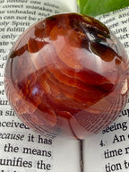close up of Carnelian sphere on book