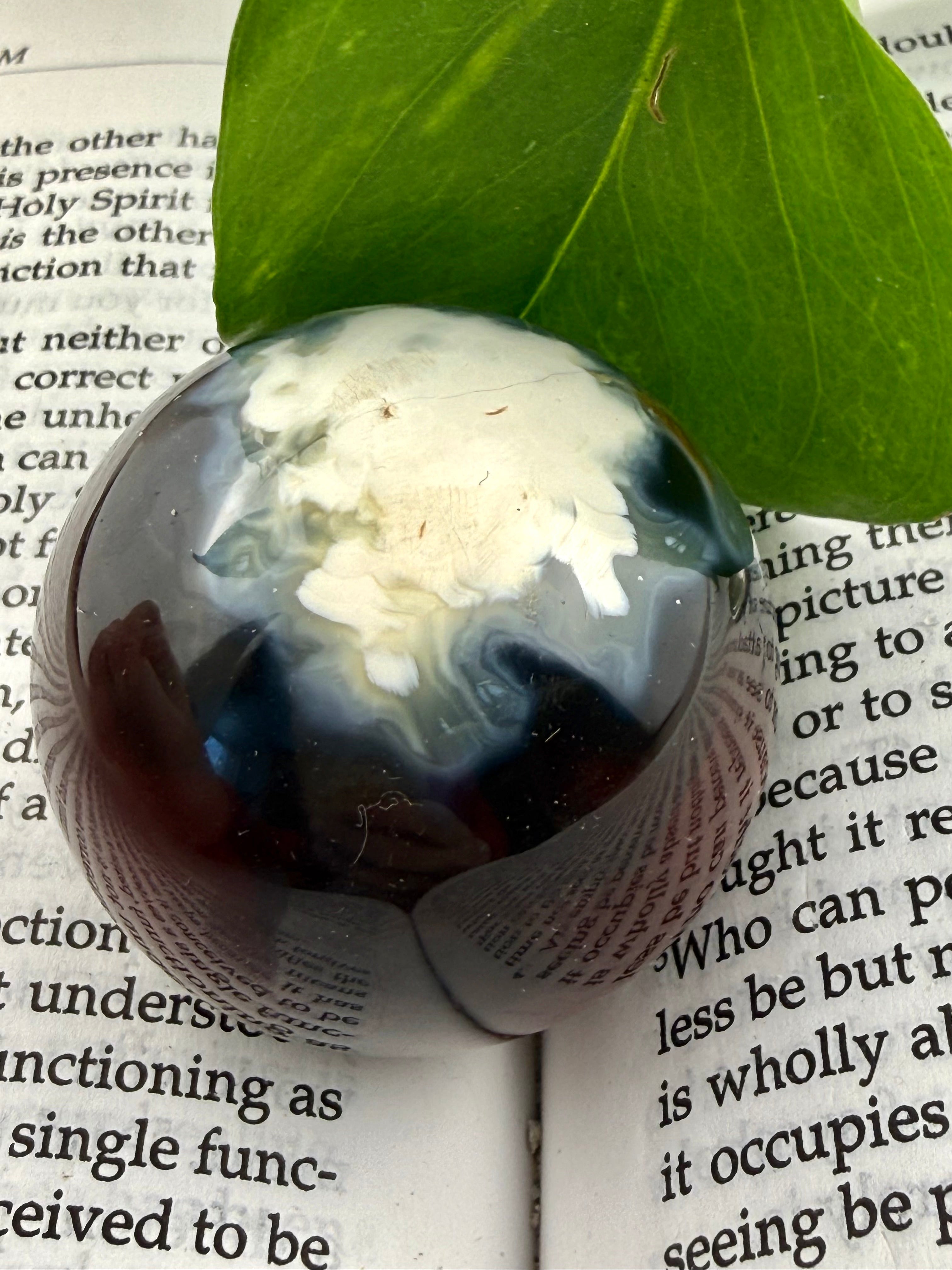 up close of dark carnelian sphere with white pattern on one size 