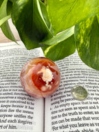 Carnelian sphere on a book with a dime to show size 