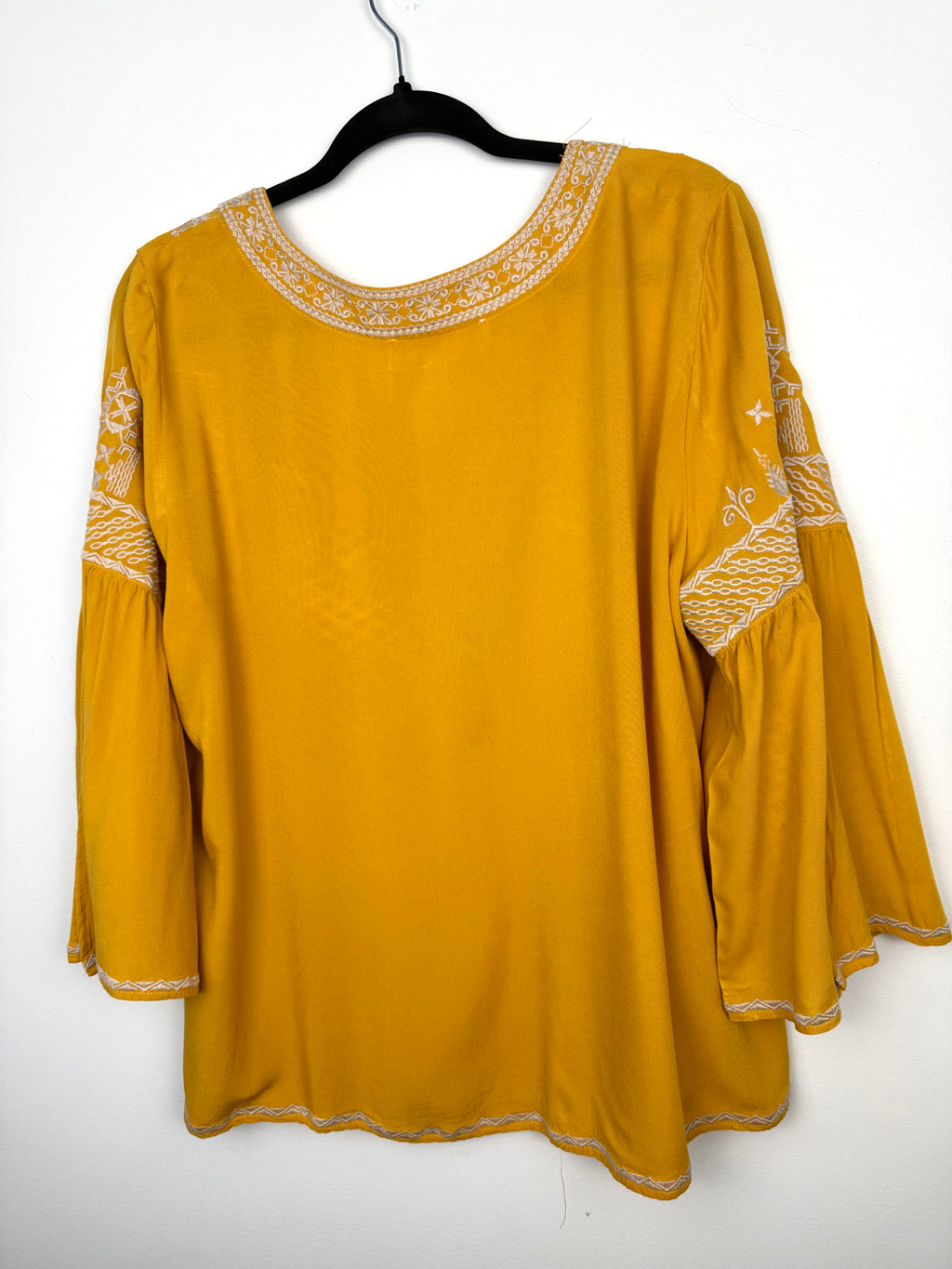 back of Chelsea & Theodore Embroidered Boho Blouse on hanger
