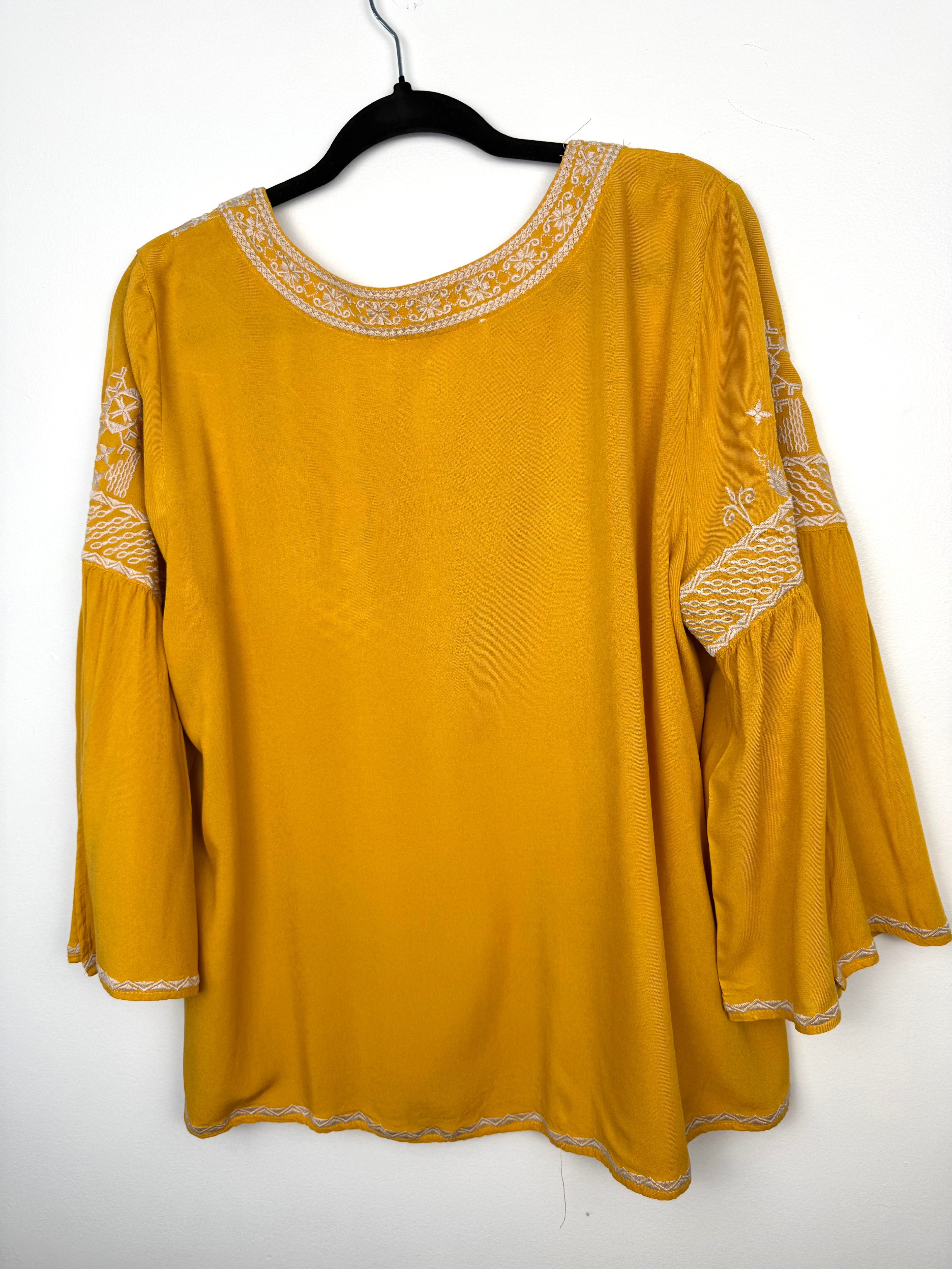 back of Chelsea & Theodore Embroidered Boho Blouse on hanger