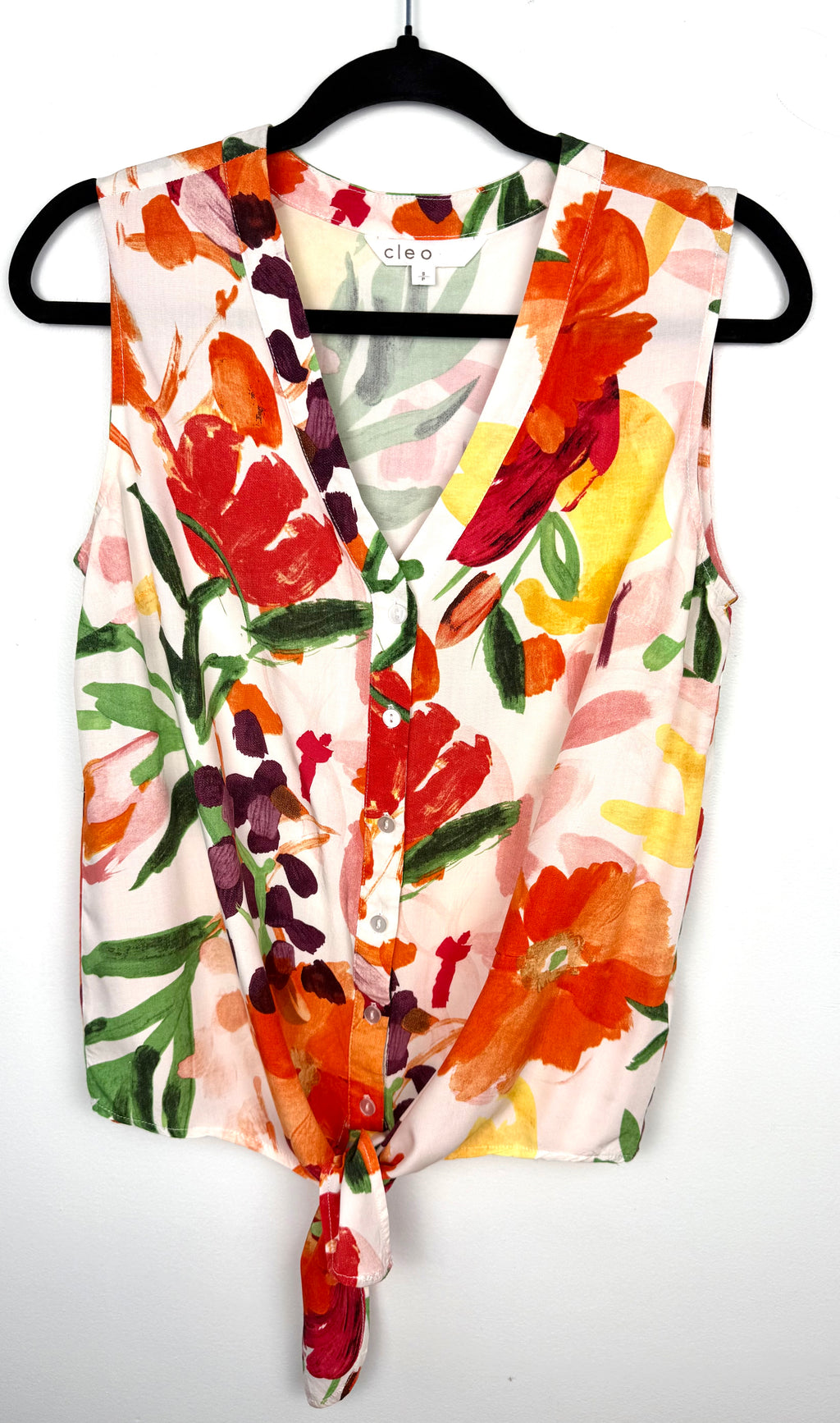 Cleo tie-front V-neck floral blouse in bold painterly orange red and green botanical print on hanger