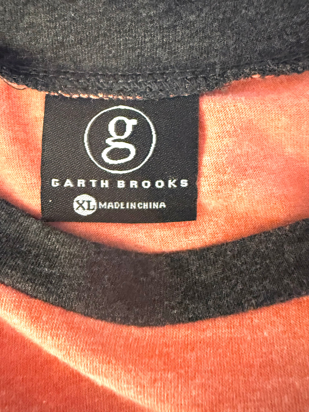 Close-up of Garth Brooks neck tag showing XL size and official branding.