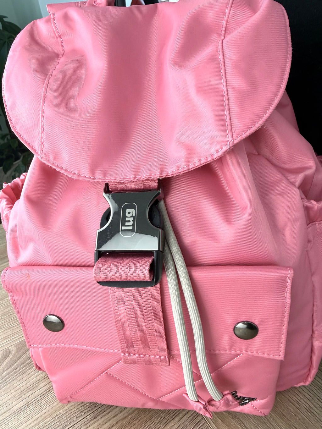 Close-up of Lug buckle and front pocket on pink Lug Wiffle backpack