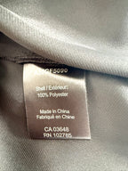 Close-up of fabric content tag showing 100% polyester, made in China.