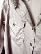 Close up of Dickies branded button and cargo flap chest pocket on dusty rose coloured herringbone work shirt.