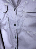 Close up of Dickies branded button and cargo flap chest pocket on dusty rose herringbone work shirt.