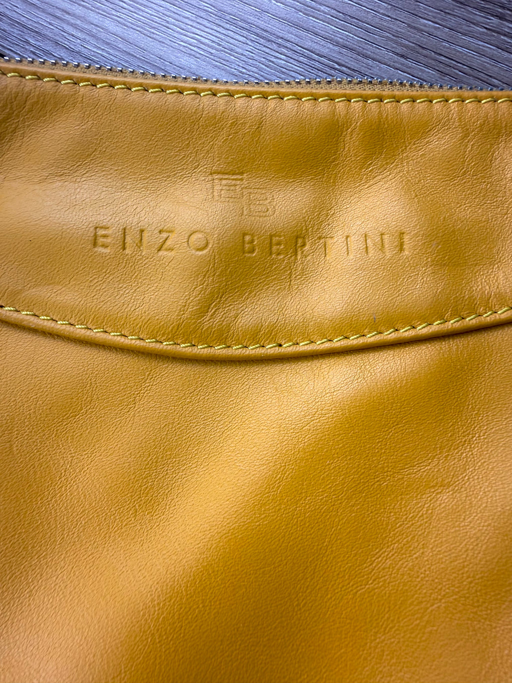 Close up of Enzo Bertini embossed logo on yellow Italian leather handbag