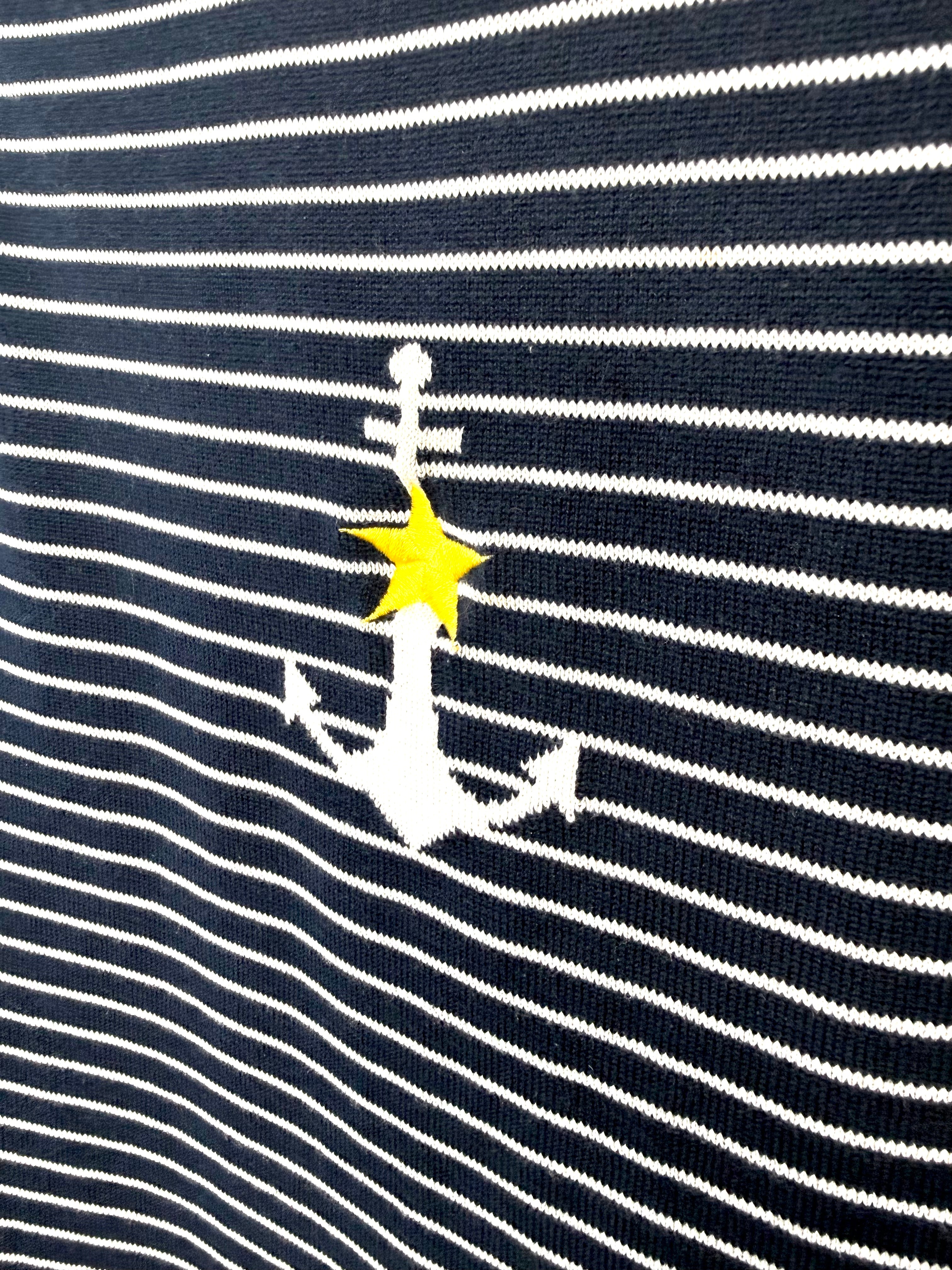 Close up of white anchor and yellow star detail on nautical striped sweater.
