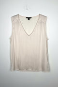 Cream Banana Republic sleeveless blouse featuring a V-neckline, gathered shoulder detail, relaxed silhouette, and fluid drape throughout the body. on white background