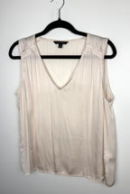 front of Cream Banana Republic sleeveless blouse featuring a V-neckline, gathered shoulder detail, relaxed silhouette, and fluid drape throughout the body. on hanger