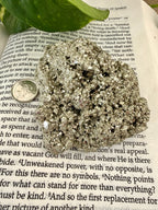 chunk of pyrite on book with dime to show scale 