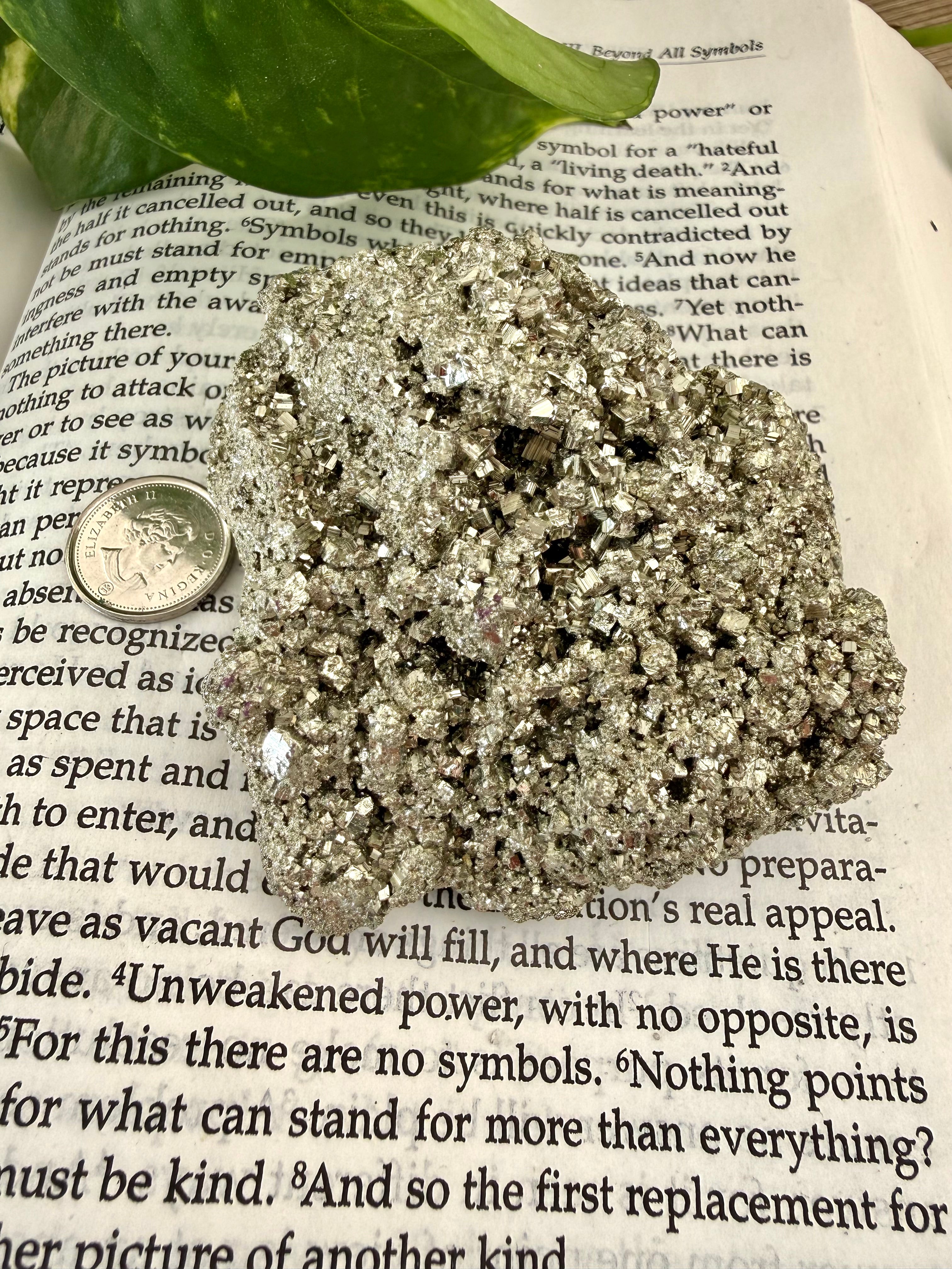 chunk of pyrite on book with dime to show scale 