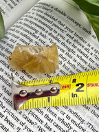 yellow fluorite with measuring tape showing it to be about 1.5"