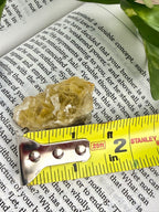 yellow fluorite with measuring tape showing it to be about 1.5"