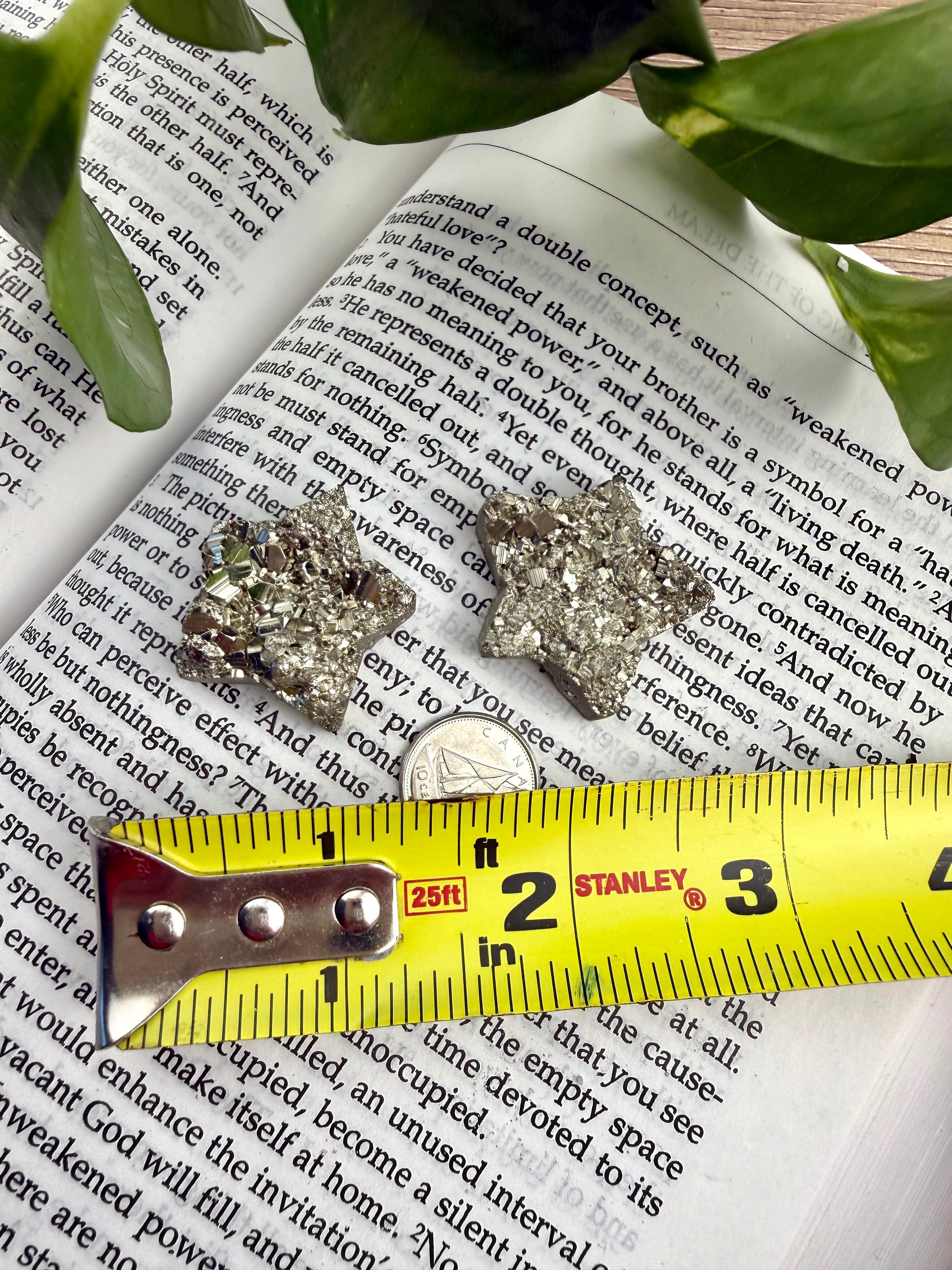 2 small pyrite stars with a measuring tape to show the size - approx 1"