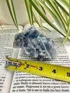 Fluorite crystal on a book with a yellow measuring tape