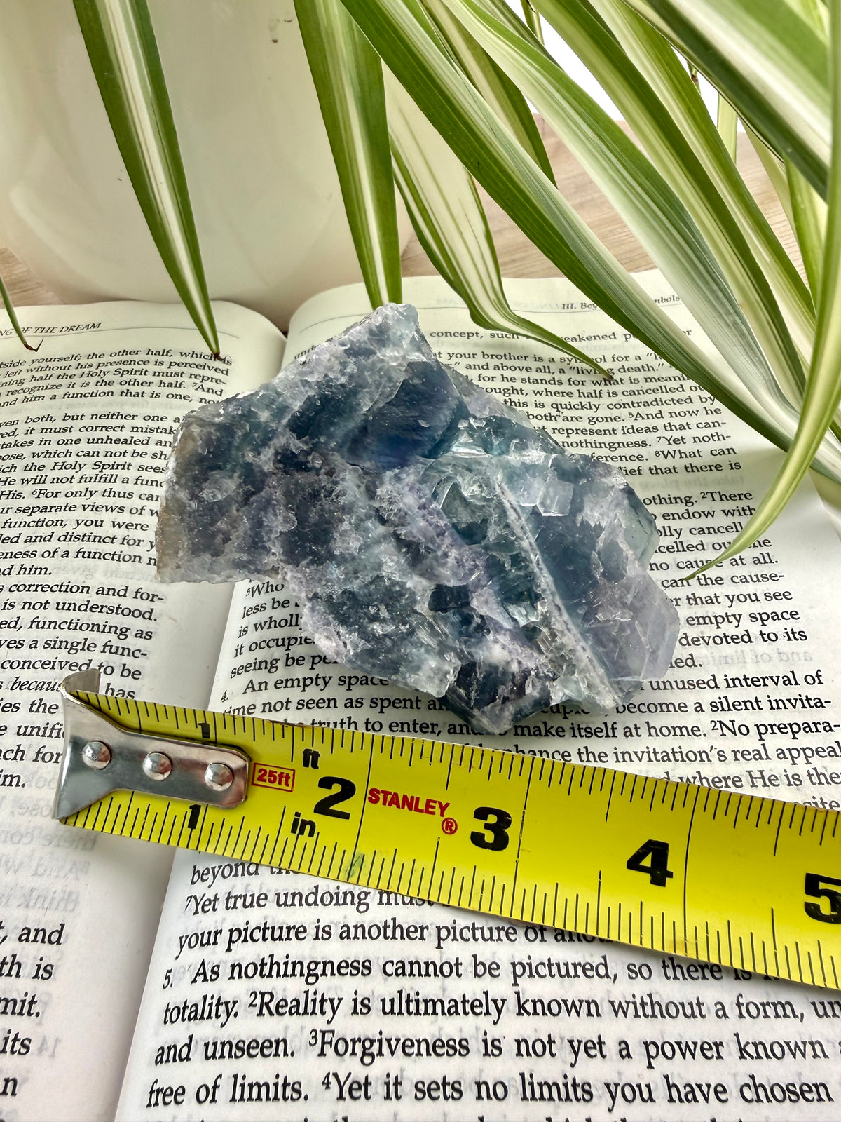 Fluorite crystal on a book with a yellow measuring tape