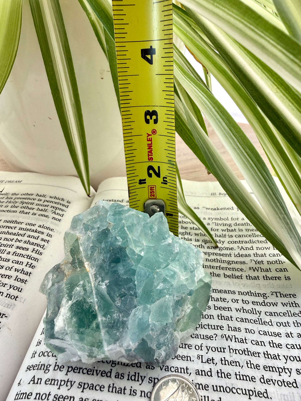 Fluorite drystal cluster on a book with a tape measure for scale