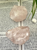 2 raw rose quartz chunks on a book 