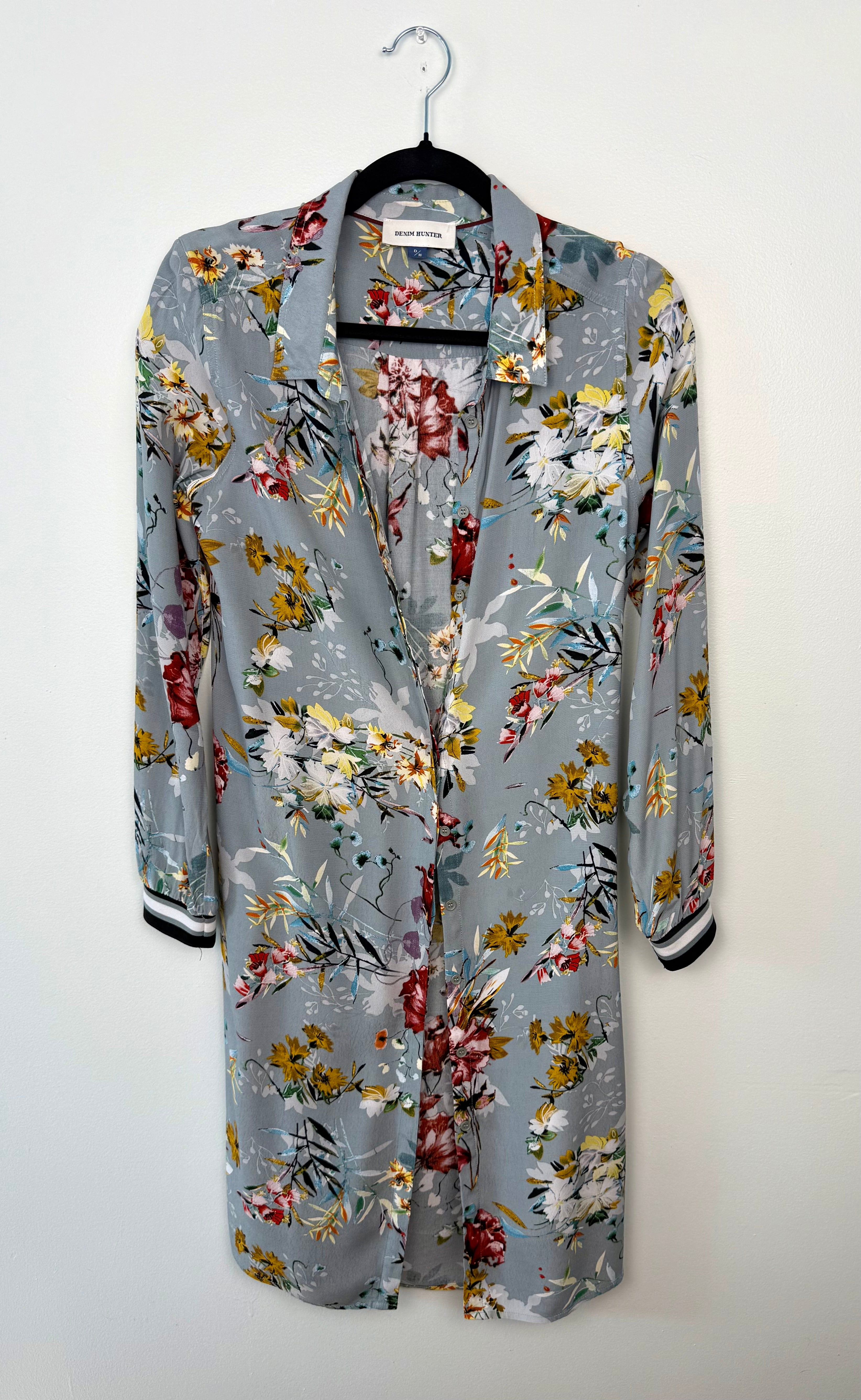 Floral-patterned shirt on a hanger against a white background