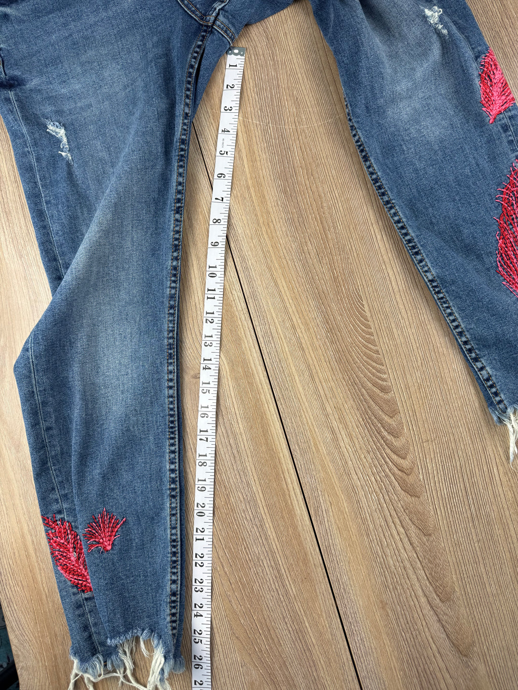 Dex embroidered feather skinny jeans medium wash distressed raw hem at Blue Sparrow Shop measuring 27" inseam 