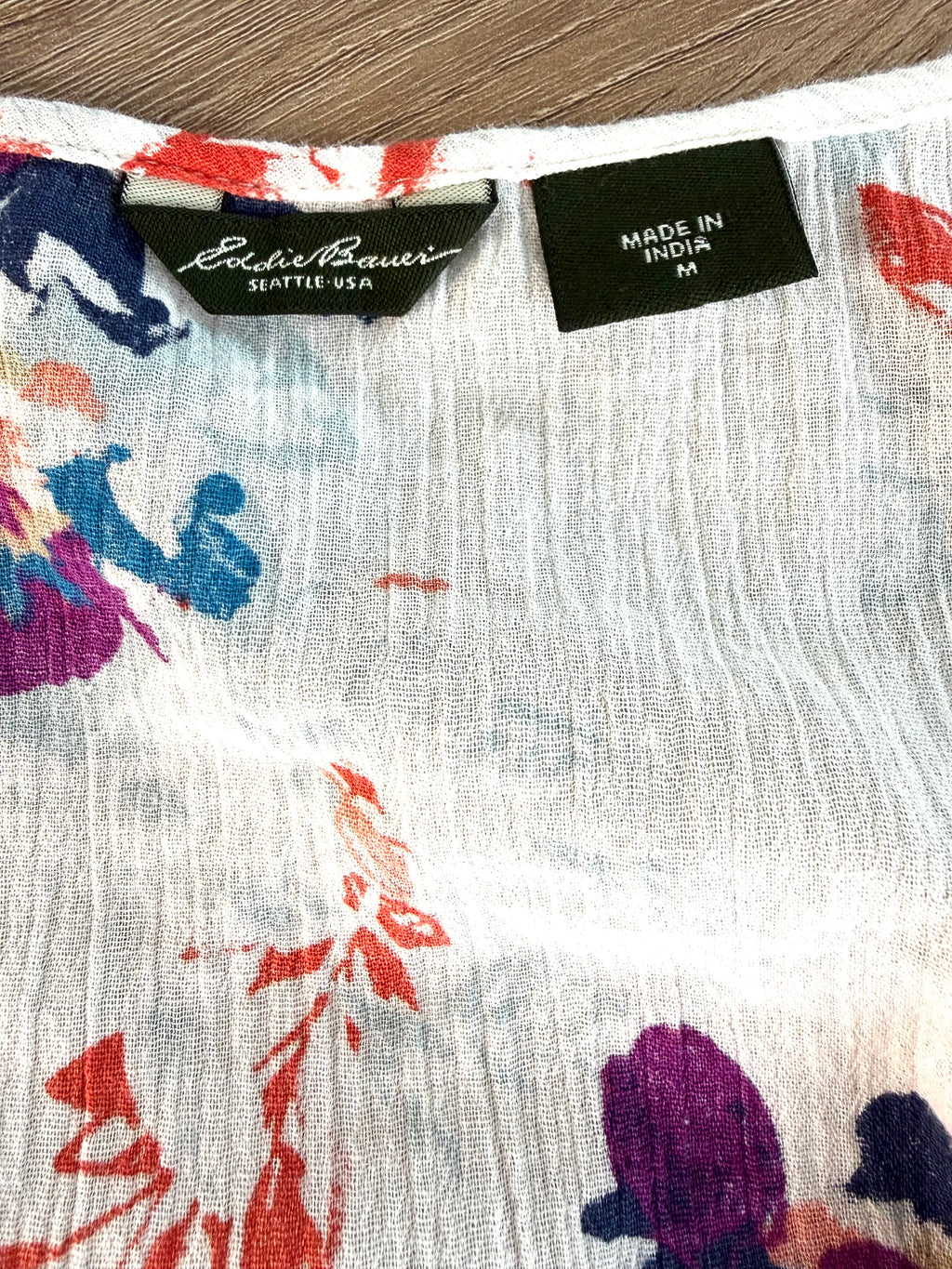 Eddie Bauer Seattle USA label and Made in India size medium tag on white floral crinkle gauze tank top — quality pre-owned women's clothing at Blue Sparrow