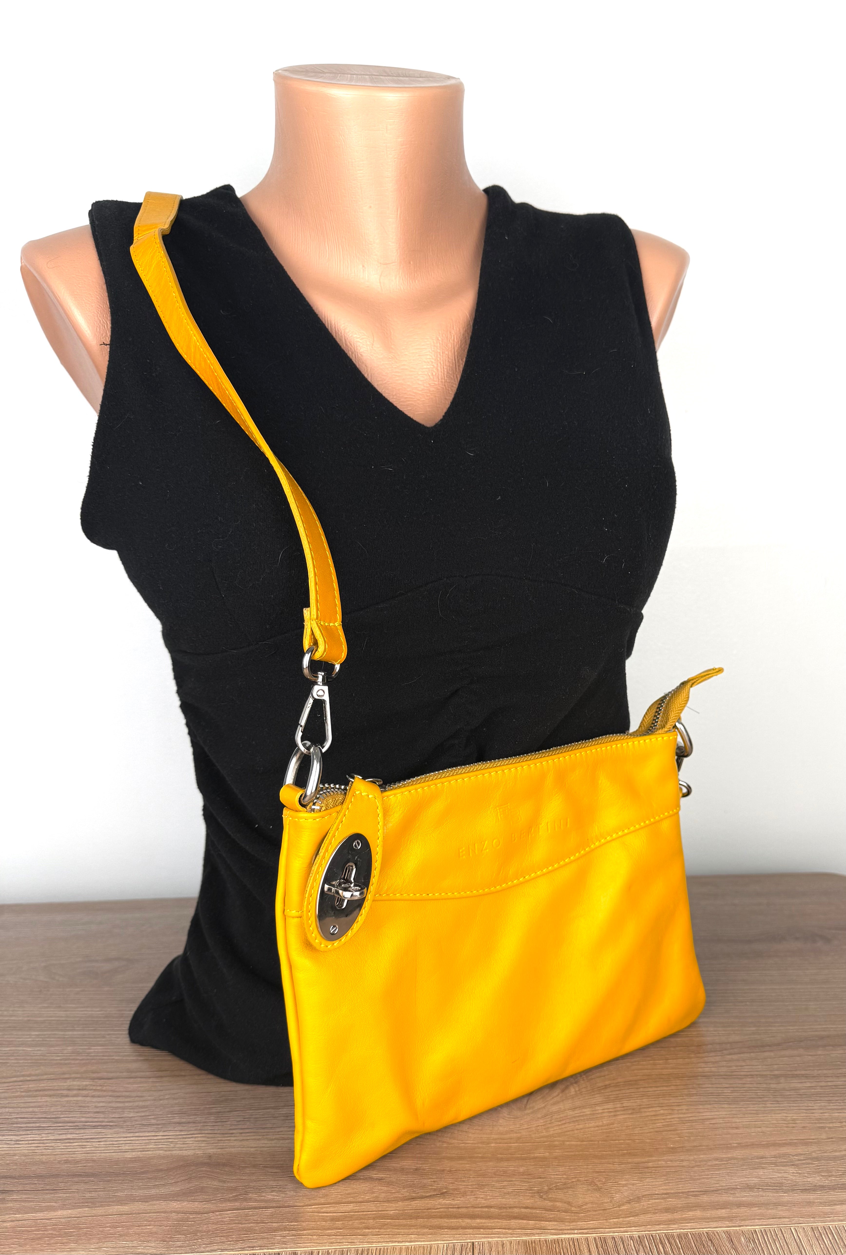 Enzo Bertini yellow leather crossbody bag with silver hardware and detachable strap, front view on mannequin