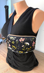 Floral cross body belt bag in navy  on mannequin to show size at another angle