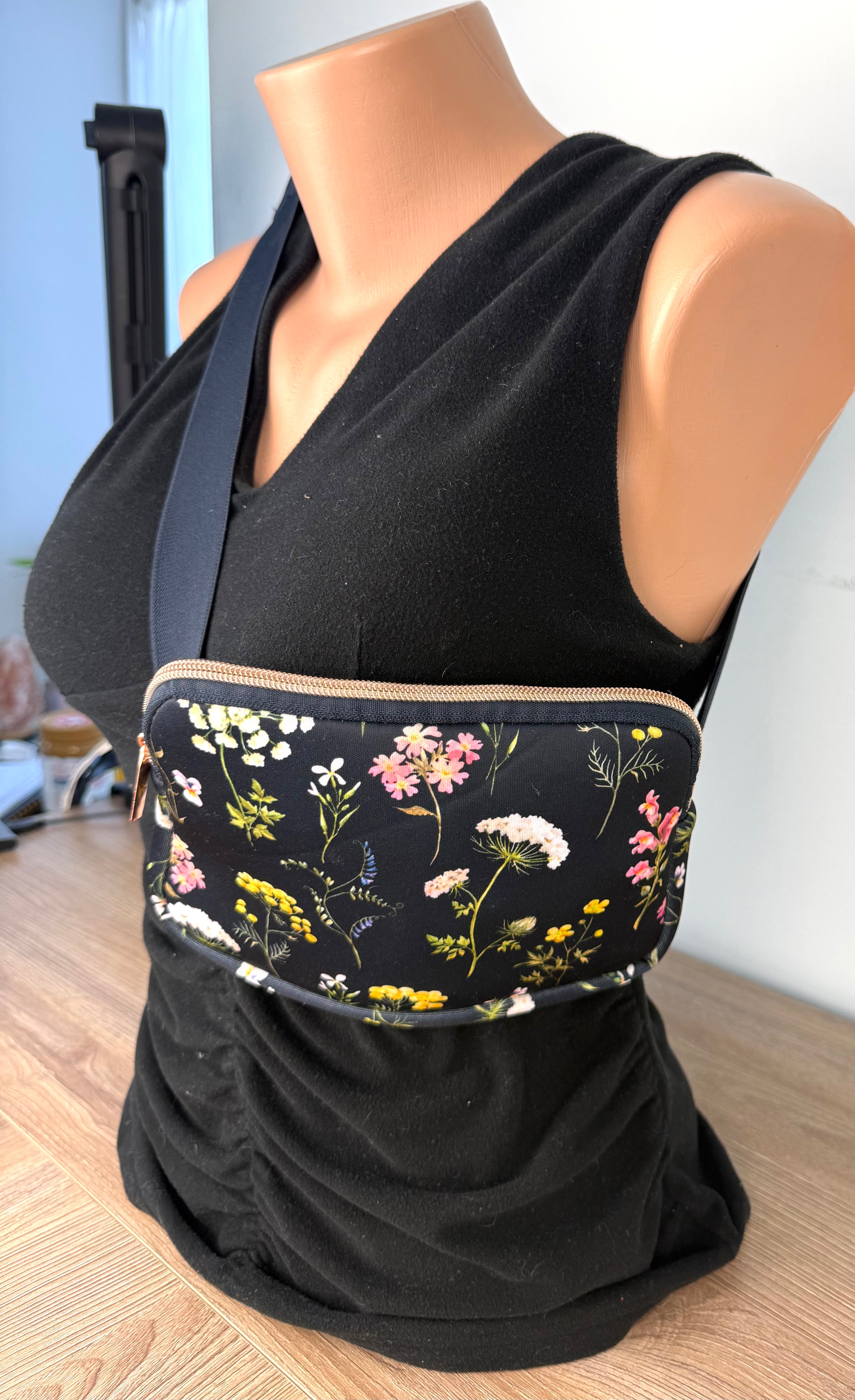 Floral cross body belt bag in navy  on mannequin to show size at another angle