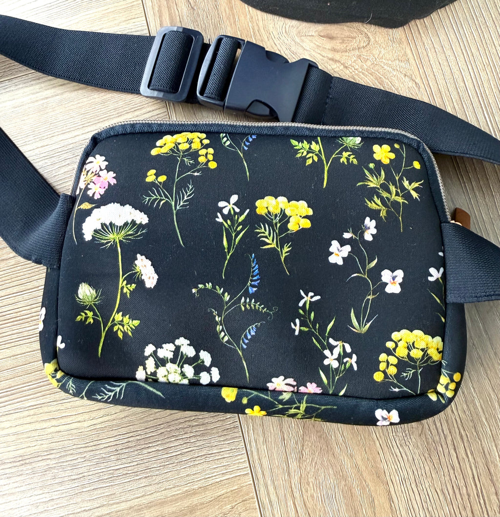 Floral cross body belt bag in navy laid flat
