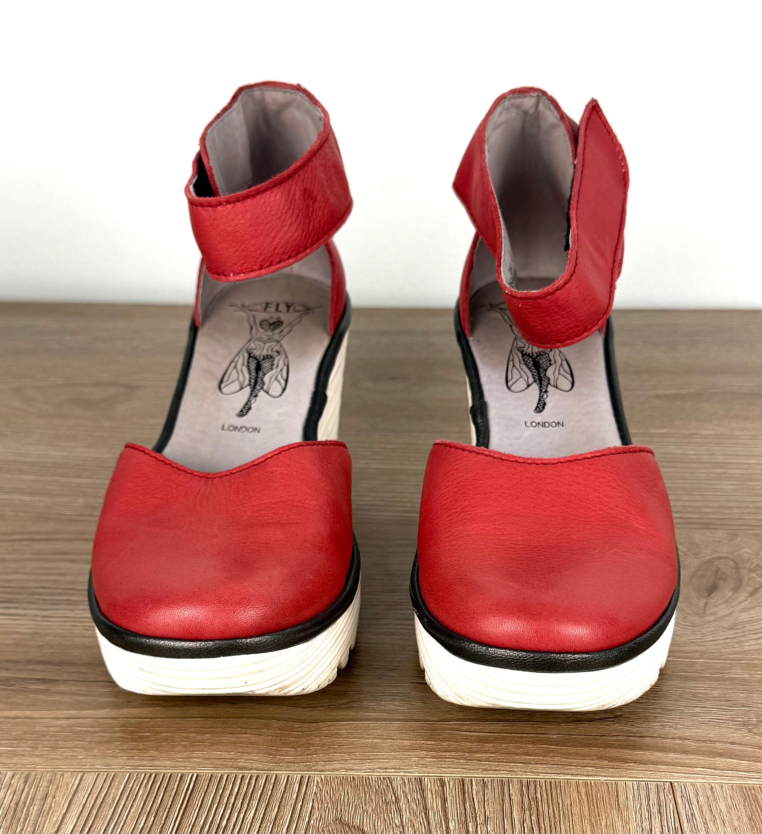 Fly London Red Leather Platform Wedge Sandals on table 