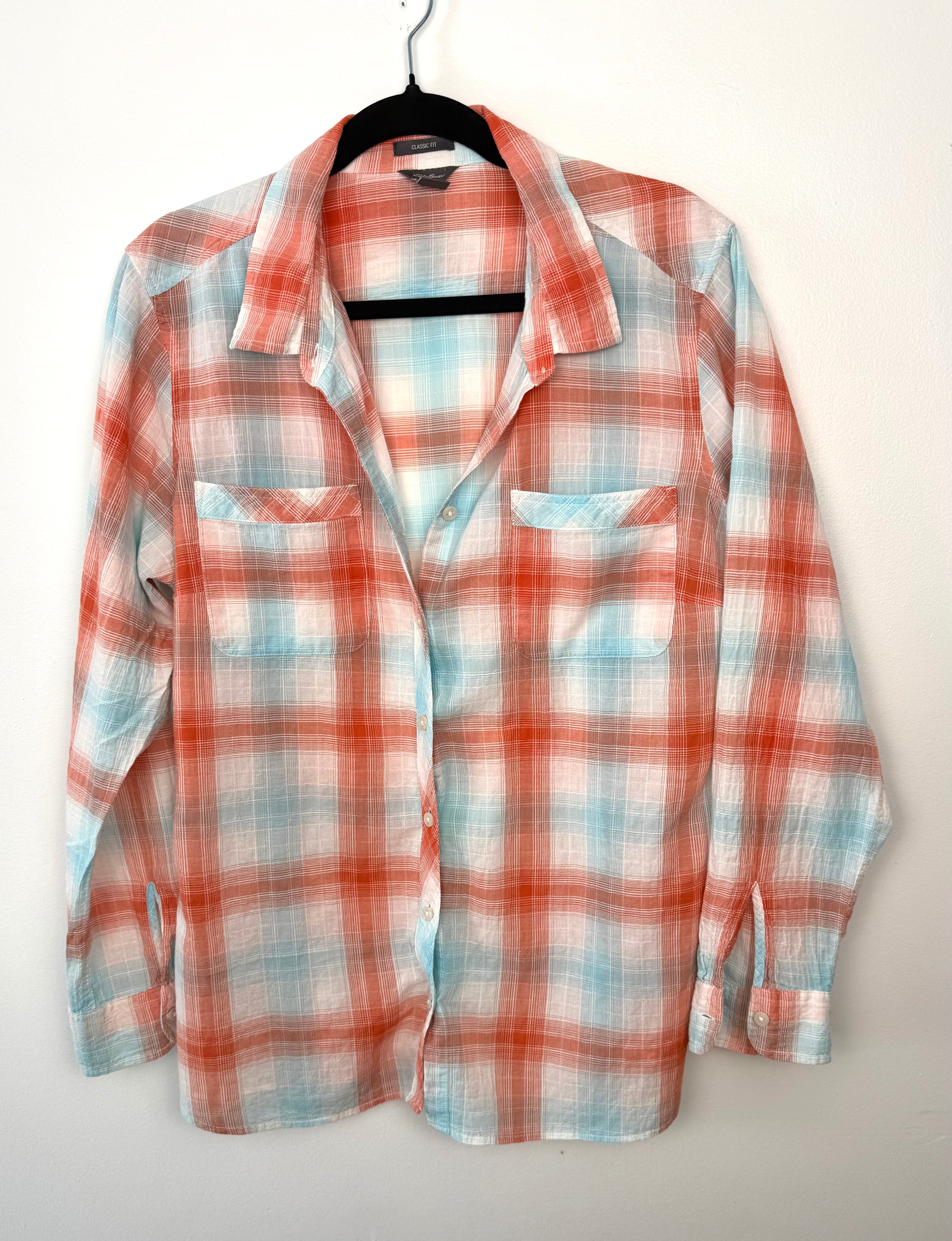 Front view of Eddie Bauer women’s classic fit plaid button-down shirt in coral and aqua, long sleeve cotton blend, size XL.