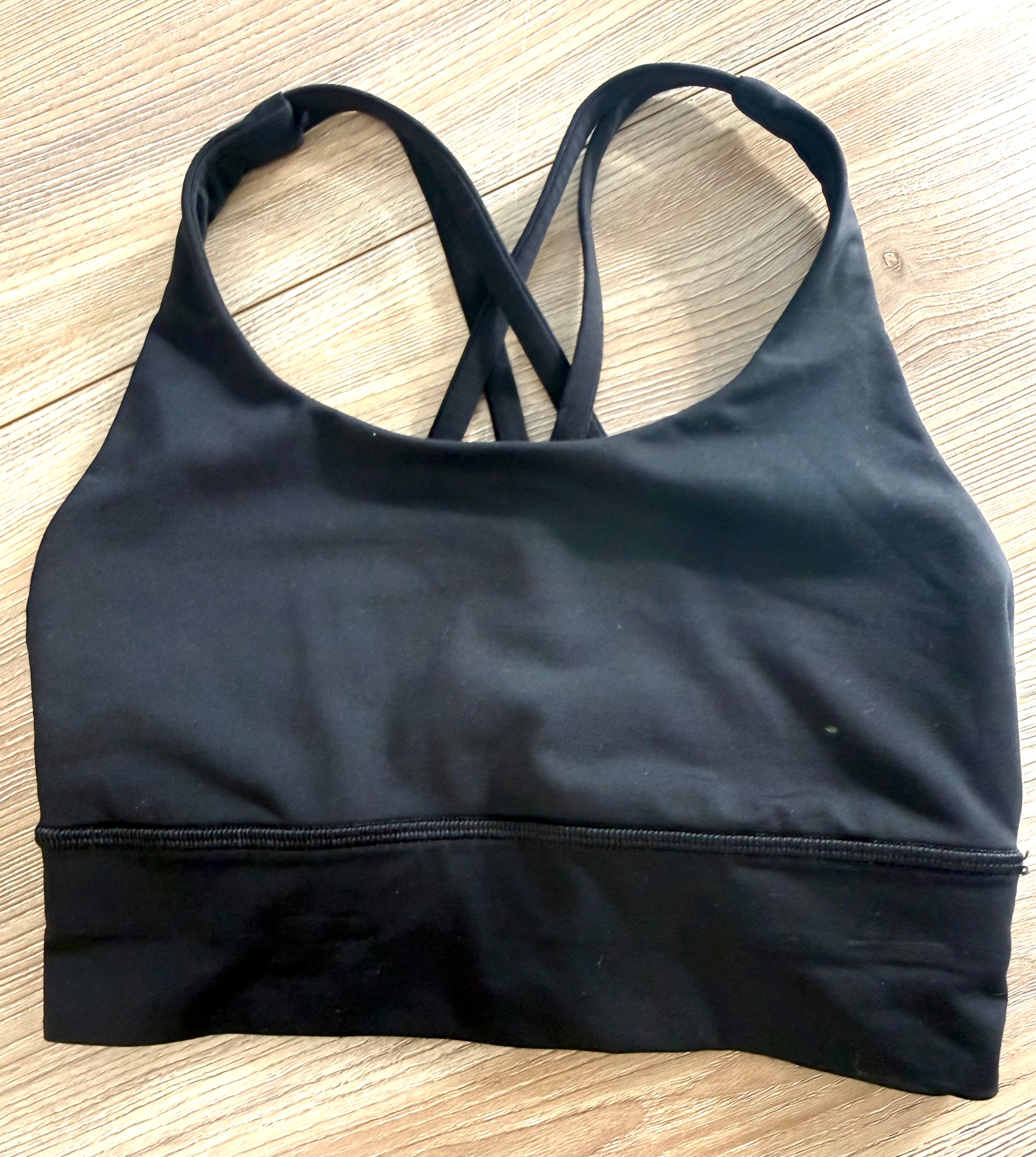 Front view of black Lululemon sports bra showing scoop neckline and wide supportive band.
