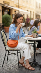 Handmade Madagascar 100% raffia orange crossbody bag leather flap  on woman at cafe 